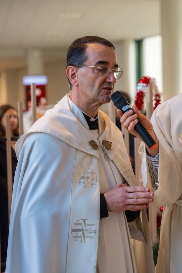 Prêtre bénissant la crèche de l'ICES